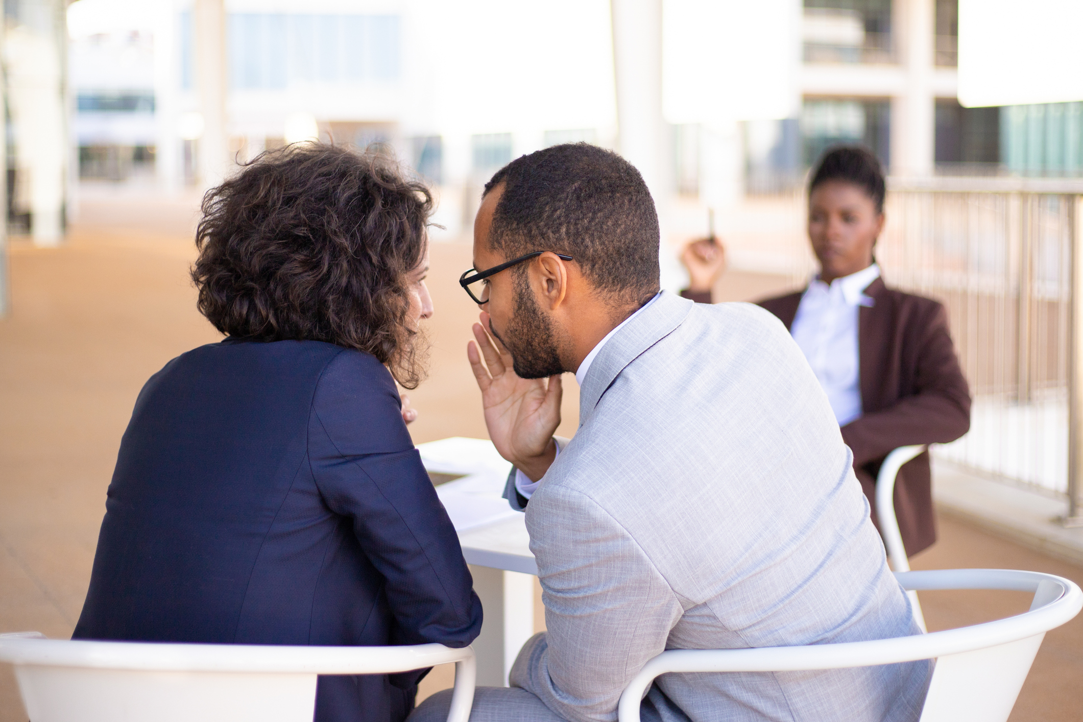 Employees gossiping about young female colleague